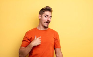 Şok olmuş ve ağzı açık, kendini işaret eden genç ve yakışıklı bir adam. Garip bıyık konsepti