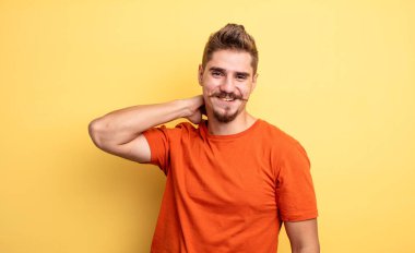 Genç ve yakışıklı bir adam neşeli ve kendinden emin bir şekilde gülüyor. Sıradan, mutlu, dostane bir gülümsemeyle. Garip bıyık konsepti