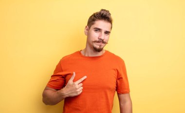 Genç yakışıklı, gururlu, kendine güvenen ve mutlu görünen, gülümseyen ve kendini gösteren ya da bir numara işareti yapan bir adam. Garip bıyık konsepti