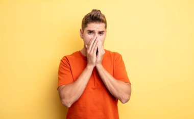 Genç, yakışıklı bir adam endişeli, üzgün ve korkmuş hissediyor. Ağzını ellerle kapatıyor. Endişeli ve berbat görünüyor. Garip bıyık konsepti
