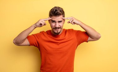 Ciddi ve konsantre görünümlü, beyin fırtınası yapan ve zorlu bir sorunu düşünen genç yakışıklı bir adam. Garip bıyık konsepti