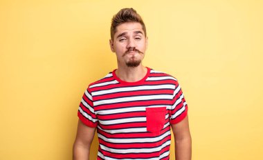 Genç yakışıklı adam dudaklarını birbirine bastırıyor, tatlı, eğlenceli, mutlu, sevimli bir yüz ifadesiyle, öpücük yolluyor. Garip bıyık konsepti