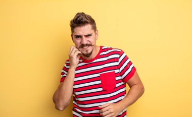 Genç ve yakışıklı bir adam stresli, hayal kırıklığına uğramış ve yorgun, endişeli ve sorunlu bir bakışla boynunu ovalıyor. Garip bıyık konsepti