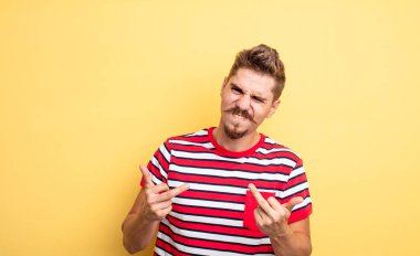 Genç yakışıklı adam kışkırtıcı, agresif ve müstehcen hissediyor. İsyankar bir tavırla orta parmağını hareket ettiriyor. Garip bıyık konsepti