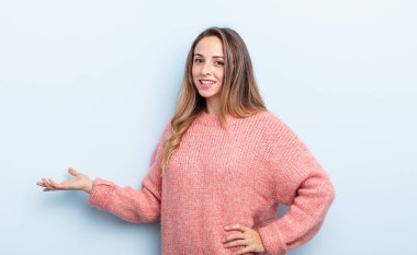 Güzel, beyaz bir kadın kendini mutlu ve neşeli hissediyor, gülümsüyor ve seni hoş karşılıyor, seni dostça bir jestle içeri davet ediyor.