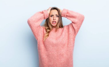 pretty caucasian woman feeling stressed, worried, anxious or scared, with hands on head, panicking at mistake
