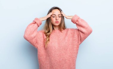 pretty caucasian woman looking concentrated, thoughtful and inspired, brainstorming and imagining with hands on forehead