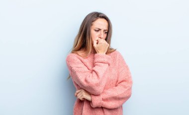 pretty caucasian woman feeling serious, thoughtful and concerned, staring sideways with hand pressed against chin