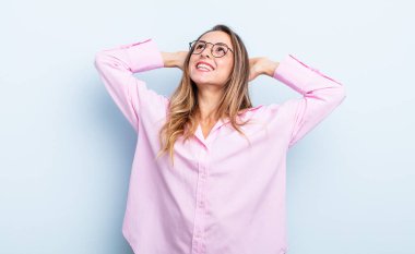 pretty caucasian woman smiling and feeling relaxed, satisfied and carefree, laughing positively and chilling