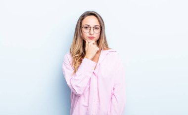 pretty caucasian woman looking serious, confused, uncertain and thoughtful, doubting among options or choices