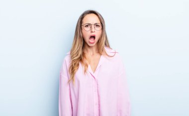 pretty caucasian woman feeling terrified and shocked, with mouth wide open in surprise