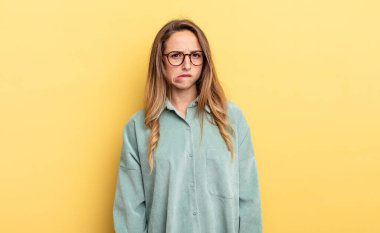 pretty caucasian woman looking puzzled and confused, biting lip with a nervous gesture, not knowing the answer to the problem