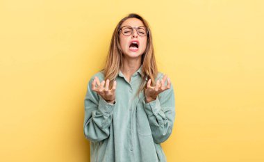 pretty caucasian woman looking desperate and frustrated, stressed, unhappy and annoyed, shouting and screaming