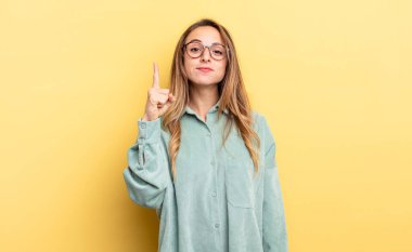 pretty caucasian woman feeling like a genius holding finger proudly up in the air after realizing a great idea, saying eureka