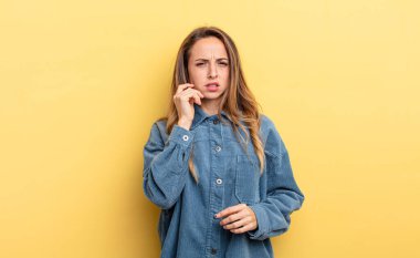 pretty caucasian woman feeling stressed, frustrated and tired, rubbing painful neck, with a worried, troubled look