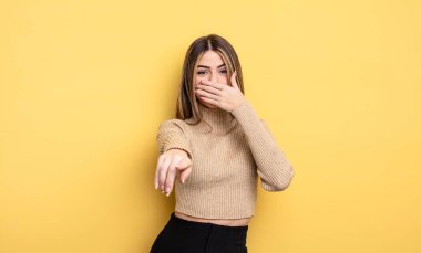 Güzel, beyaz bir kadın sana gülüyor, kamerayı işaret ediyor ve seninle dalga geçiyor ya da alay ediyor.