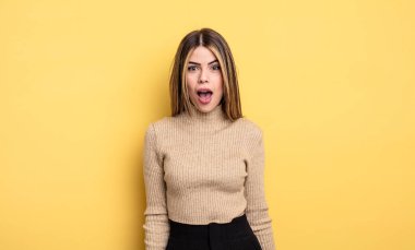 pretty caucasian woman looking very shocked or surprised, staring with open mouth saying wow
