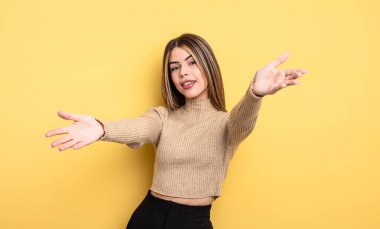 pretty caucasian woman smiling cheerfully giving a warm, friendly, loving welcome hug, feeling happy and adorable