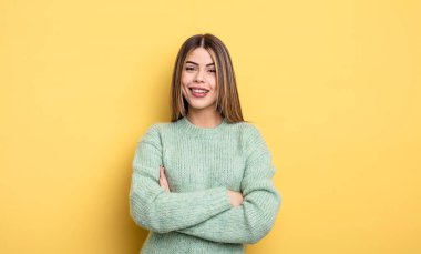 pretty caucasian woman looking like a happy, proud and satisfied achiever smiling with arms crossed