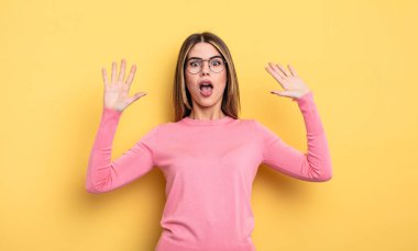 pretty caucasian woman feeling stupefied and scared, fearing something frightening, with hands open up front saying stay away
