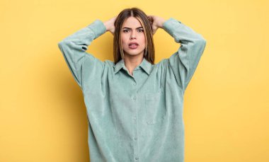 pretty caucasian woman feeling stressed, worried, anxious or scared, with hands on head, panicking at mistake