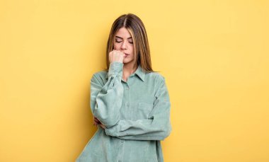 pretty caucasian woman feeling serious, thoughtful and concerned, staring sideways with hand pressed against chin