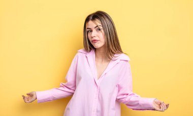 pretty caucasian woman feeling clueless and confused, having no idea, absolutely puzzled with a dumb or foolish look