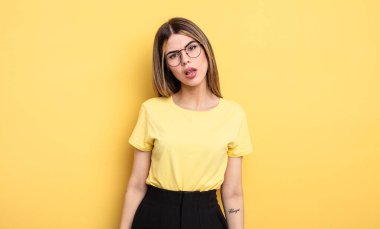 pretty caucasian woman feeling puzzled and confused, with a dumb, stunned expression looking at something unexpected