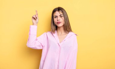 pretty caucasian woman feeling like a genius holding finger proudly up in the air after realizing a great idea, saying eureka