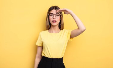 pretty caucasian woman greeting the camera with a military salute in an act of honor and patriotism, showing respect