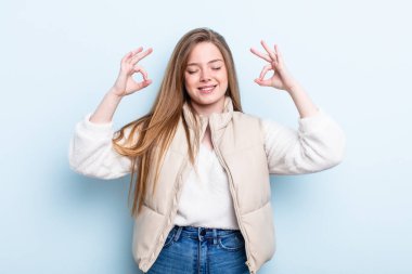 Kafkasyalı kızıl saçlı kadın konsantre olmuş ve meditasyon yapıyor, tatmin olmuş ve rahatlamış hissediyor, düşünüyor ya da bir seçim yapıyor.