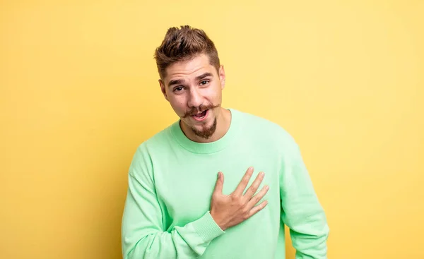 Jovem Homem Bonito Sentindo Chocado Surpreso Sorrindo Tomando Mão Coração — Fotografia de Stock