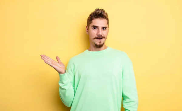 Jovem Bonito Homem Olhando Surpreso Chocado Com Mandíbula Caiu Segurando — Fotografia de Stock