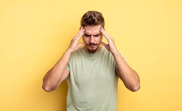 young handsome man looking concentrated, thoughtful and inspired, brainstorming and imagining with hands on forehead. strange moustache concept