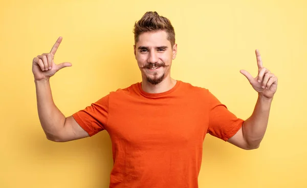 年轻英俊的男人用双手塑造或勾勒出自己的笑容 看上去积极而快乐 健康的概念 奇怪的胡子概念 — 图库照片