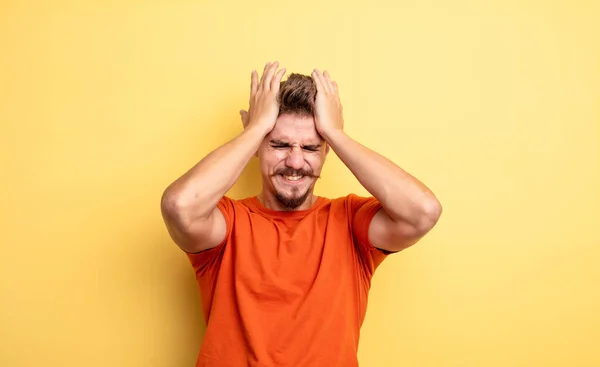 若いハンサムな男は 頭に両手を上げて 頭の痛みにストレスと不安 落ち込んで不満を感じている 奇妙な口ひげの概念 — ストック写真