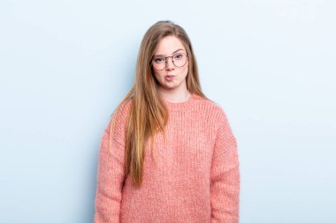 Kafkasyalı kızıl saçlı kadın kendini şaşkın ve şüpheli hissediyor, merak ediyor ya da karar vermeye çalışıyor.