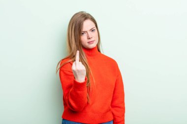 Kafkasyalı kızıl saçlı kadın kızgın, sinirli, asi ve agresif hissediyor, orta parmağını sallıyor, karşı koyuyor.