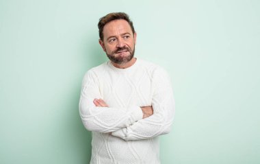 Orta yaşlı, yakışıklı, şüpheci ya da düşünen, dudağını ısıran, kendine güveni olmayan ve gergin bir adam.