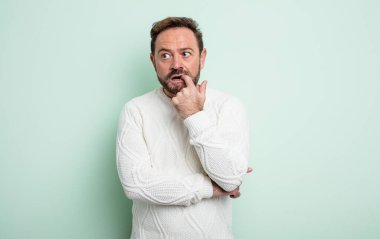 Şaşırmış, gergin, endişeli ya da korkmuş bakışları olan orta yaşlı yakışıklı bir adam fotokopi alanına doğru bakıyor.