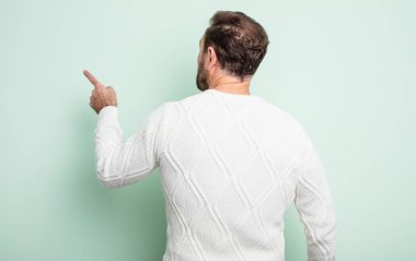 Orta yaşlı yakışıklı adam dikey ve dikiz boşluğunda duran ve objeye işaret eden