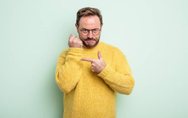 Orta yaşlı, yakışıklı, sabırsız ve sinirli görünen, saati gösteren, dakiklik isteyen, zamanında gelmek isteyen bir adam.
