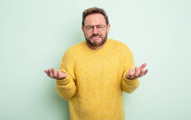 Orta yaşlı, yakışıklı ve kafası karışık bir adam, hangi seçeneği seçeceğinden emin değil, merak ediyor.