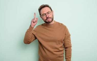 Orta yaşlı yakışıklı bir adam, harika bir fikri fark ettikten sonra parmağını havaya kaldırıp 