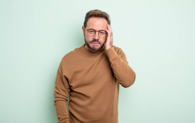 Orta yaşlı yakışıklı bir adam yorgun, sıkıcı ve sıkıcı bir işten sonra sıkılmış, hayal kırıklığına uğramış ve uykulu hisseder.