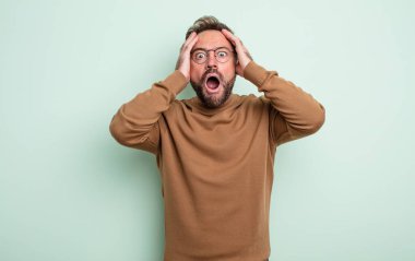 Orta yaşlı, yakışıklı, dehşete kapılmış ve şok olmuş hisseden, el ele tutuşan ve hata yaptığında panikleyen bir adam.