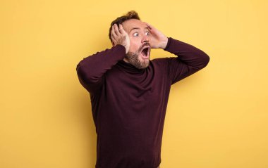 Orta yaşlı, ağzı açık yakışıklı bir adam korkunç bir hata yüzünden dehşete düşmüş ve şok olmuş görünüyor.