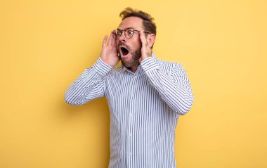 Orta yaşlı, yakışıklı, mutlu, heyecanlı ve şaşırmış bir adam. İki eli de havada bir tarafa bakıyor.