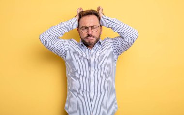 Orta yaşlı yakışıklı bir adam hayal kırıklığına uğramış ve sıkılmış, başarısızlıktan bıkmış, sıkıcı, sıkıcı işlerden bıkmış