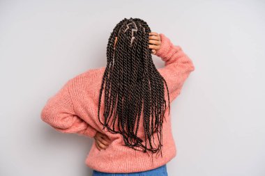 Siyah afro kadın düşünüyor ya da şüphe ediyor, kafasını kaşıyor, şaşkın ve şaşkın hissediyor, arkaya ya da arkaya bakıyor.